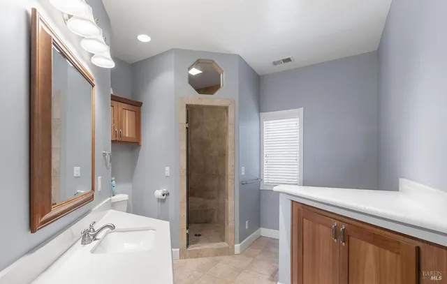 a bathroom with a sink and mirror with bathtub