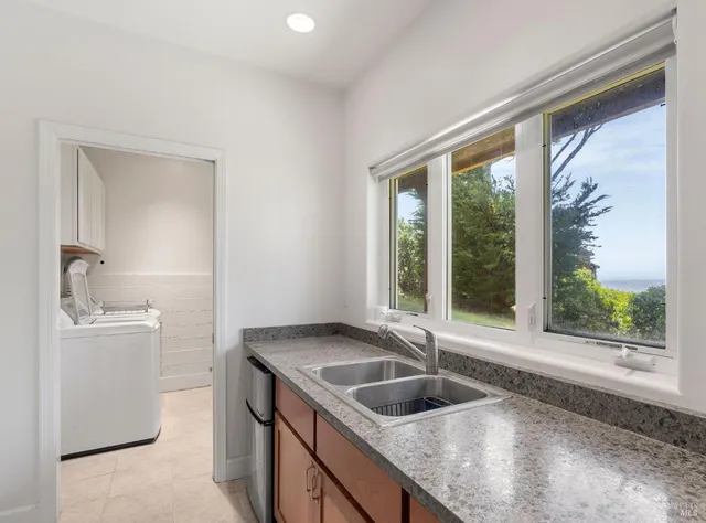 a kitchen with granite countertop a sink and a refrigerator