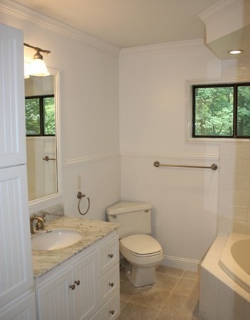 8 Ridge Road, Unit 1 Lincoln, MA 01773 - Photo 11 of 14 a bathroom with a granite countertop toilet a sink and a window