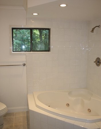 8 Ridge Road, Unit 1 Lincoln, MA 01773 - Photo 12 of 14 a white bath tub sitting next to a toilet