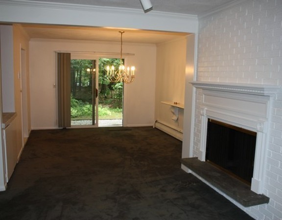 8 Ridge Road, Unit 1 Lincoln, MA 01773 - Photo 5 of 14 a living room with a fireplace and a large window