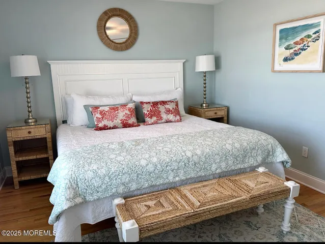 a bedroom with a bed and a lamp on dresser