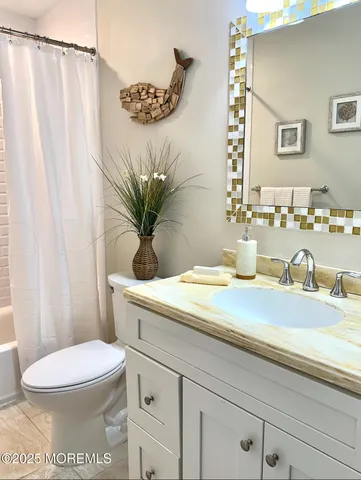a bathroom with a granite countertop sink a toilet and a mirror