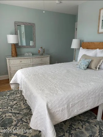 a bedroom with a bed and a lamp on dresser