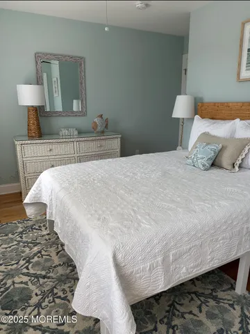 a bedroom with a bed and a lamp on dresser