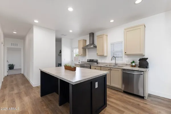 a kitchen with a sink appliances and wooden floor