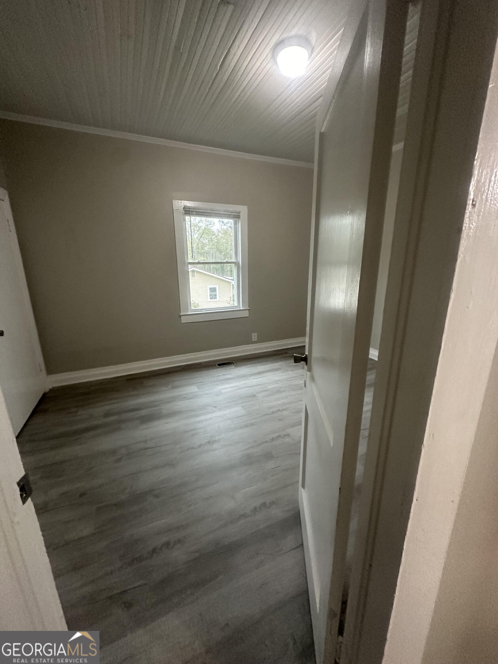 193 Frazier Drive Southeast Milledgeville, GA 31061 - Photo 21 of 38 a view of an empty room with wooden floor and a window