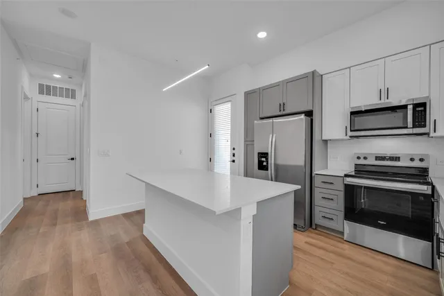 a large kitchen with a sink and refrigerator