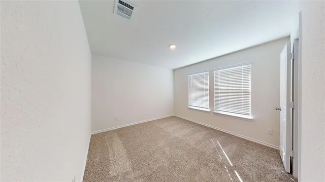 a view of a hallway with wooden floor and a bathroom