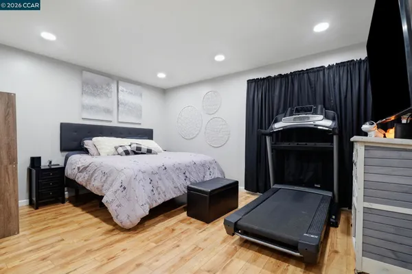 a bedroom with a bed and painting on the wall