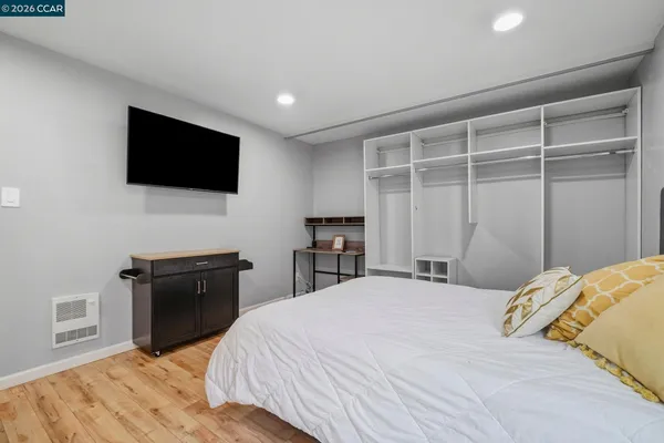 a bedroom with a large bed and wooden floor
