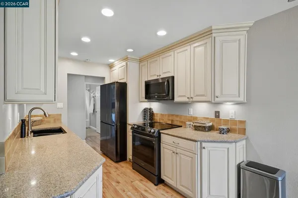 a kitchen with stainless steel appliances a sink a stove top oven a counter space and cabinets