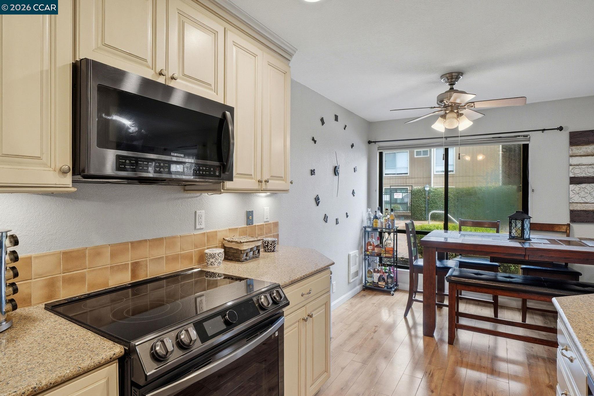 9025 Alcosta Boulevard, Unit 259 San Ramon, CA 94583 - Photo 10 of 40 a kitchen with a stove a microwave and wooden floor