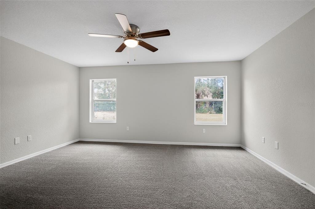 11443 Southwest 78th Circle Ocala, FL 34476 - Photo 16 of 33 an empty room with windows and fan