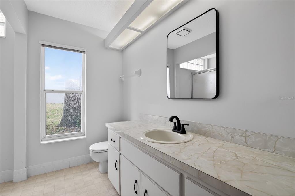 11443 Southwest 78th Circle Ocala, FL 34476 - Photo 20 of 33 a bathroom with a toilet sink and mirror