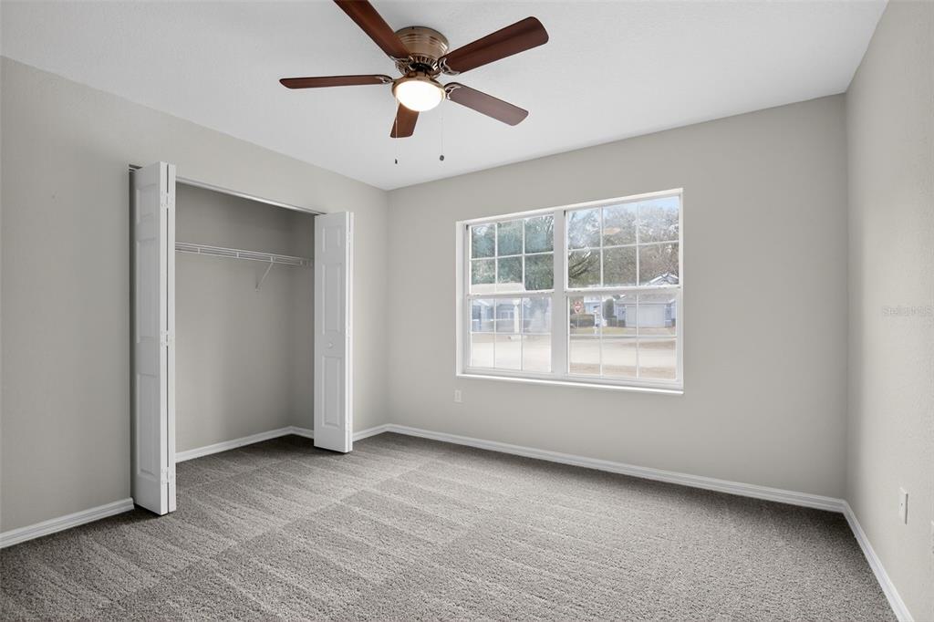 11443 Southwest 78th Circle Ocala, FL 34476 - Photo 21 of 33 an empty room with a empty space and a ceiling fan