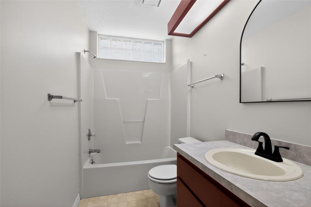 11443 Southwest 78th Circle Ocala, FL 34476 - Photo 23 of 33 a bathroom with a sink toilet a mirror and shower