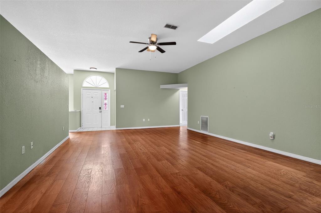 11443 Southwest 78th Circle Ocala, FL 34476 - Photo 5 of 33 wooden floor in an empty room with a window