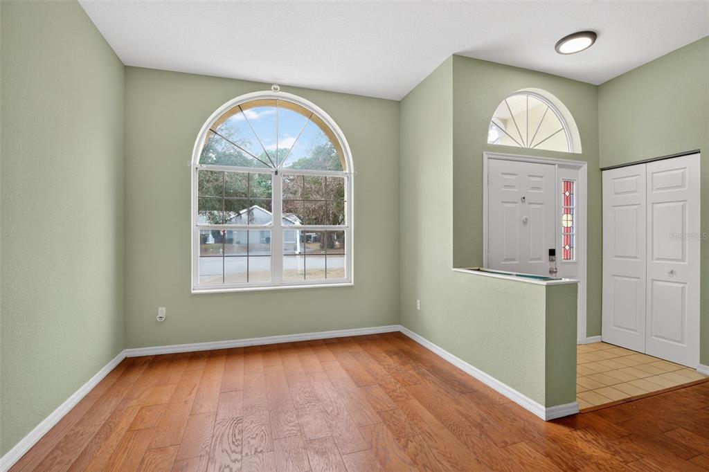 11443 Southwest 78th Circle Ocala, FL 34476 - Photo 8 of 33 an empty room with wooden floor a painting and a window