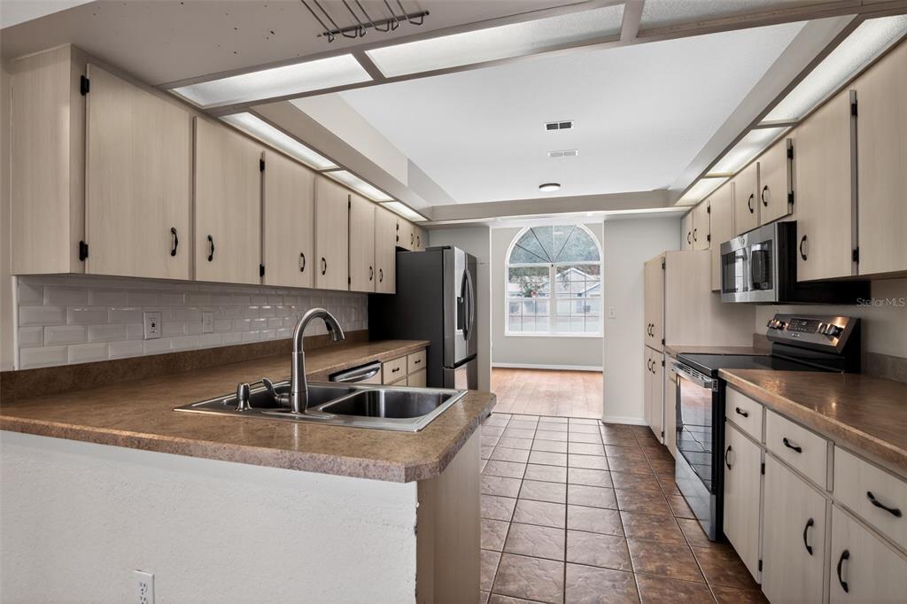 11443 Southwest 78th Circle Ocala, FL 34476 - Photo 9 of 33 a kitchen with stainless steel appliances granite countertop a sink a stove and cabinets