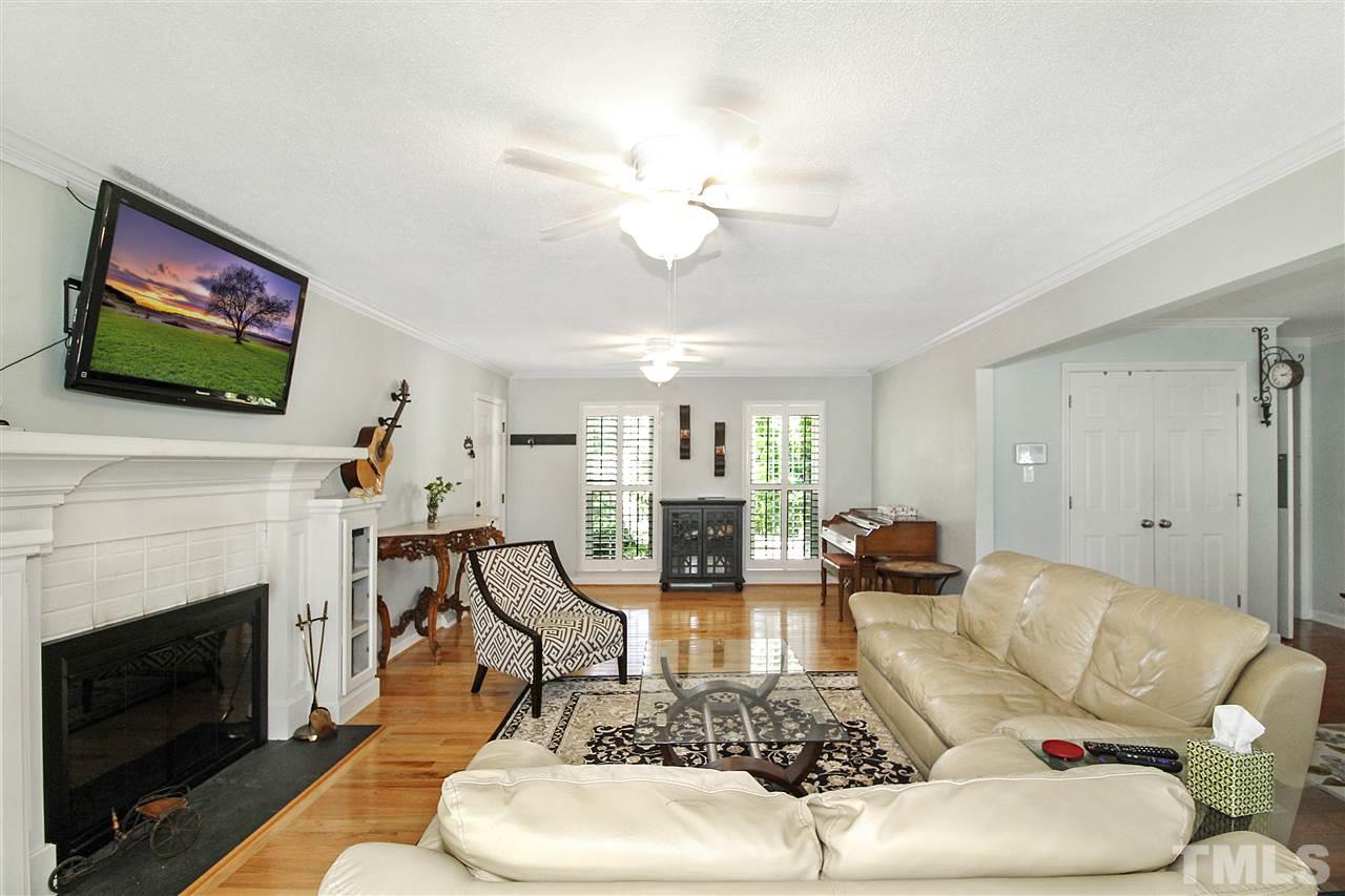 1408 Hunting Ridge Road Raleigh, NC 27615 - Photo 3 of 25 a living room with furniture a fireplace and a flat screen tv