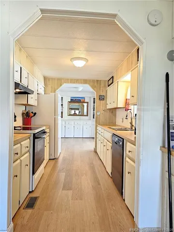 a large kitchen with a stove a sink dishwasher and a refrigerator