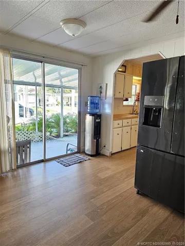 a view of a kitchen with refrigerator wooden floor and furniture