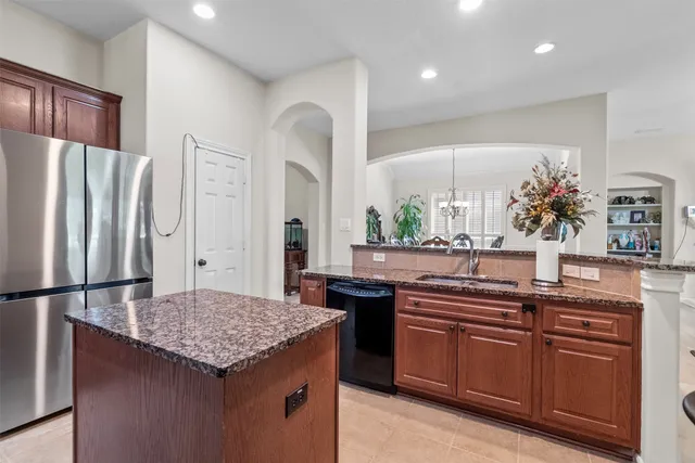 a kitchen with stainless steel appliances granite countertop a sink and a refrigerator