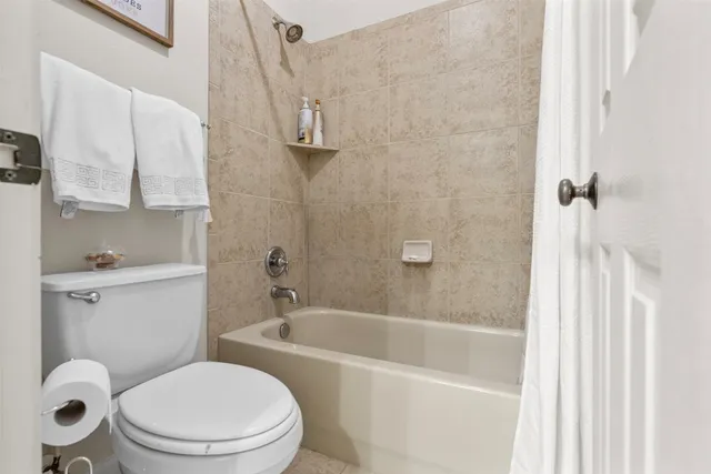 a white toilet sitting next to a bath tub