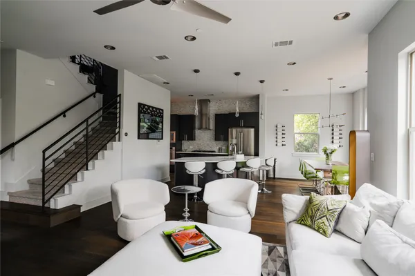 a living room with furniture a wooden floor and a chandelier