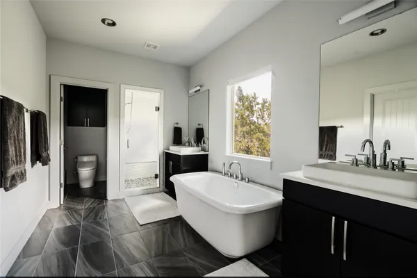 a spacious bathroom with a double vanity sink a mirror and a bathtub