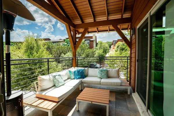 a balcony with wooden floor and outdoor seating