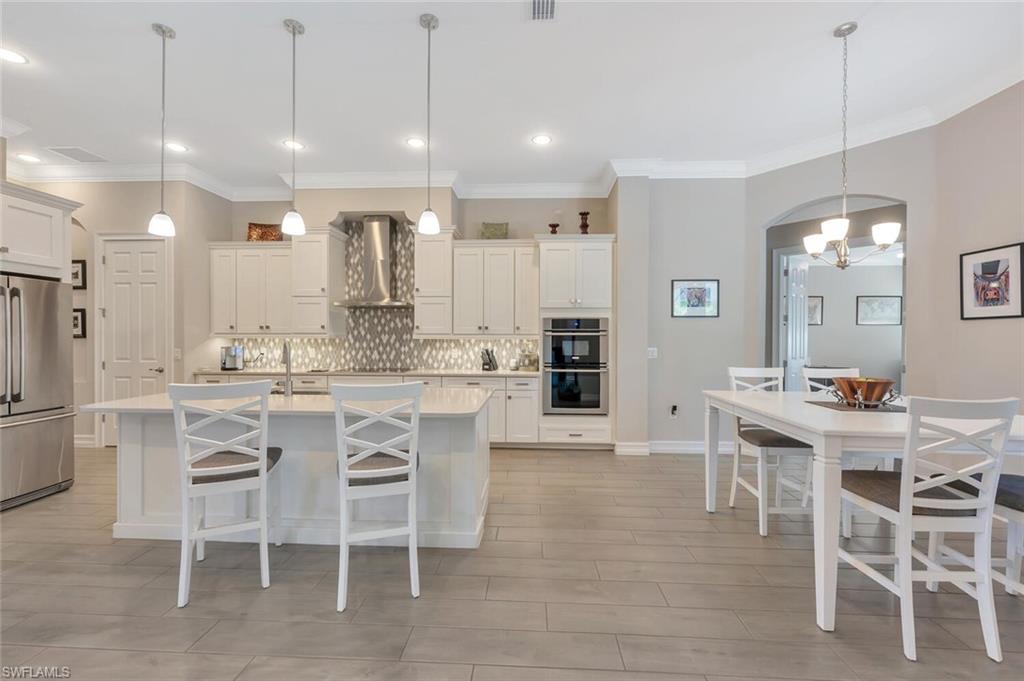 1451 Mockingbird Drive Naples, FL 34120 - Photo 12 of 42 a large kitchen with a table and chairs