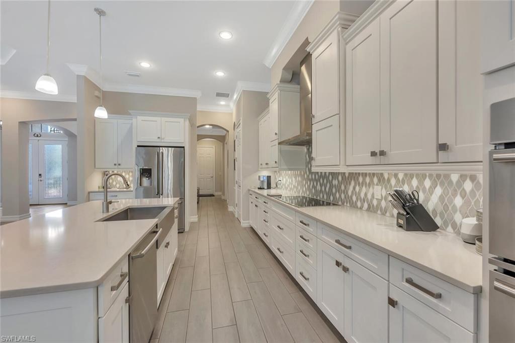 1451 Mockingbird Drive Naples, FL 34120 - Photo 15 of 42 a large kitchen with kitchen island a sink stainless steel appliances and cabinets