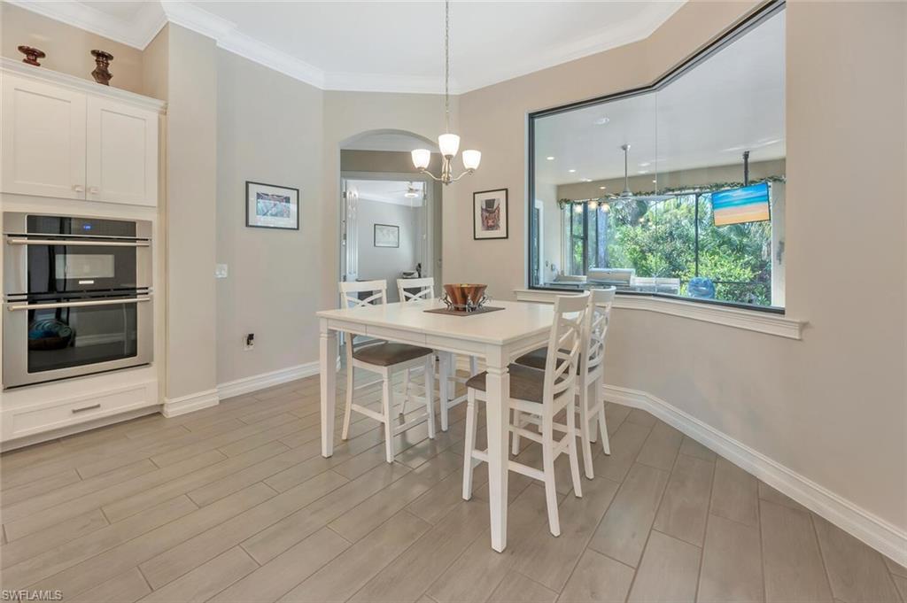 1451 Mockingbird Drive Naples, FL 34120 - Photo 17 of 42 a dining room with furniture a floor to ceiling window and wooden floor
