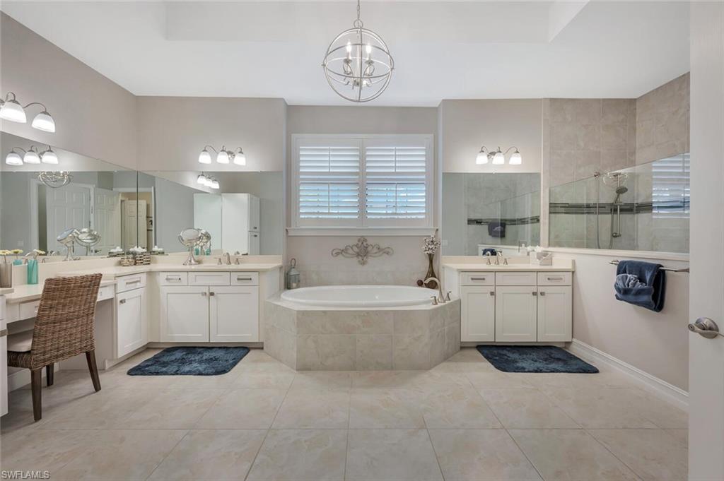 1451 Mockingbird Drive Naples, FL 34120 - Photo 26 of 42 a bathroom with a bathtub a sink a mirror and a shower