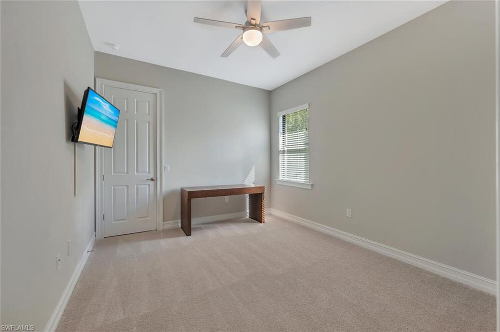 1451 Mockingbird Drive Naples, FL 34120 - Photo 29 of 42 an empty room with windows and ceiling fan
