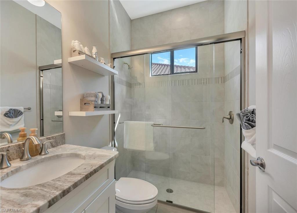 1451 Mockingbird Drive Naples, FL 34120 - Photo 30 of 42 a bathroom with a granite countertop sink toilet and shower