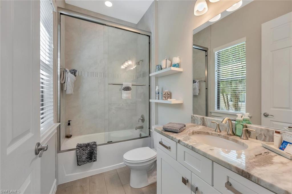 1451 Mockingbird Drive Naples, FL 34120 - Photo 33 of 42 a bathroom with a granite countertop sink toilet and shower