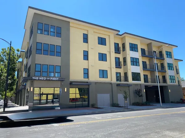 a front view of a building with glass windows and a table
