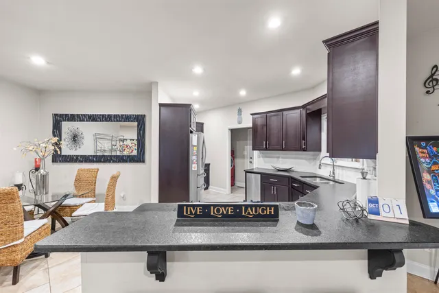 a view of kitchen with kitchen island stainless steel appliances sink stove and window