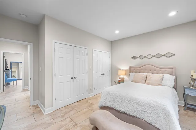 a spacious bedroom with a bed and a chandelier