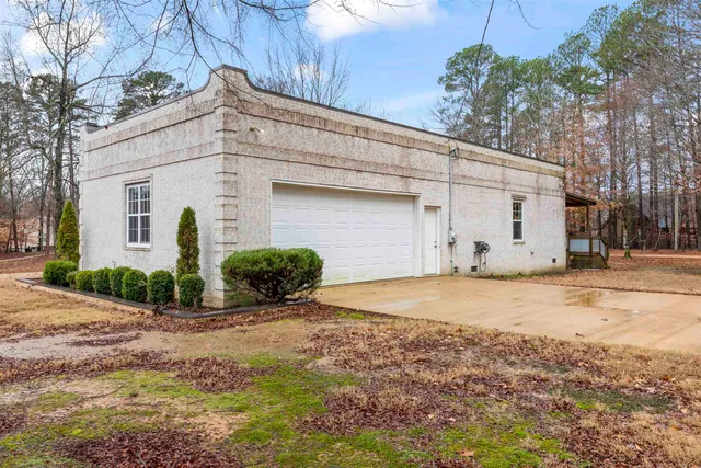 a view of a white house with a large trees