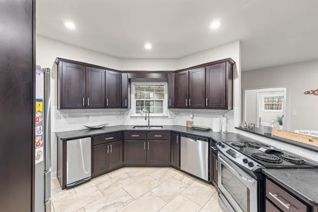a kitchen with stainless steel appliances granite countertop a sink stove and cabinets