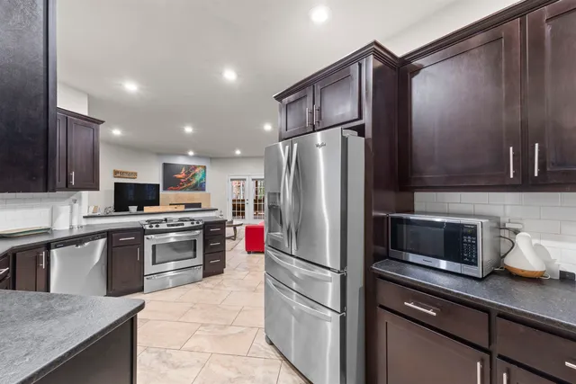 a kitchen with stainless steel appliances a refrigerator sink and microwave