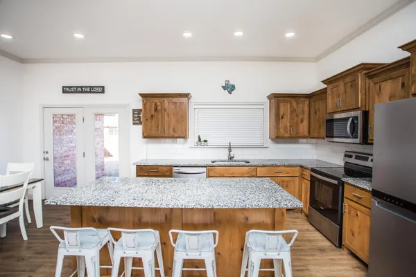 a kitchen with stainless steel appliances granite countertop sink wooden cabinets and granite counter tops