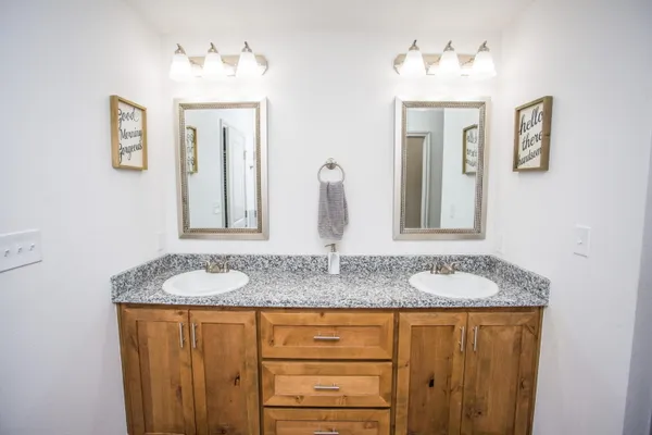 a bathroom with a granite countertop sink and a mirror