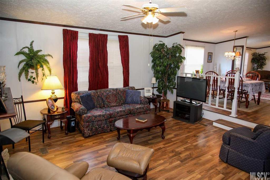 8843 Mull Road Vale, NC 28168 - Photo 3 of 25 a living room with furniture a chandelier and a flat screen tv