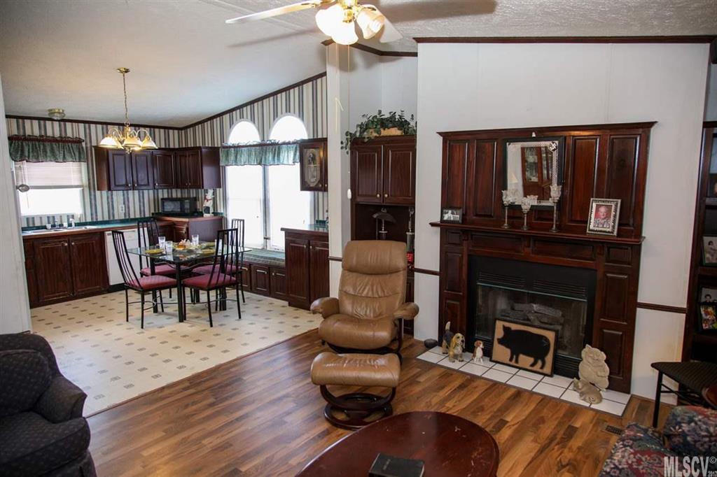 8843 Mull Road Vale, NC 28168 - Photo 4 of 25 a living room with furniture a fireplace and a dining table with wooden floor