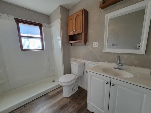 a bathroom with a toilet sink a mirror and vanity